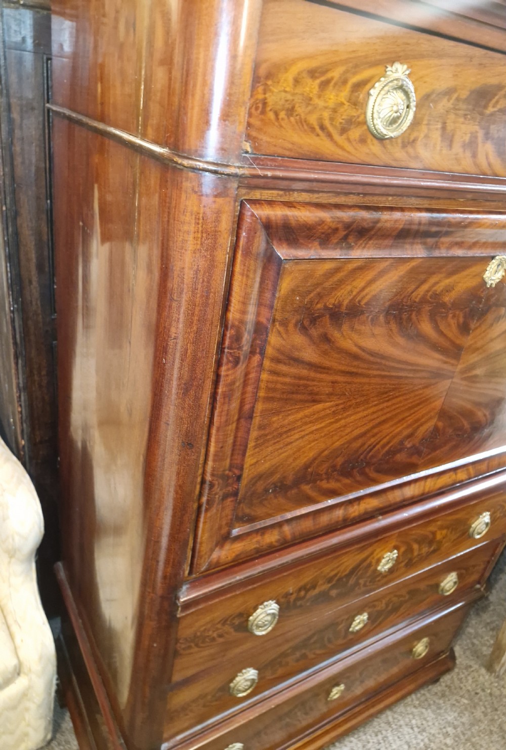 A 19th-century mahogany fall-front escritoire featuring flame mahogany veneer panels, a drop-down writing surface, multiple storage drawers, and brass fittings. View IX