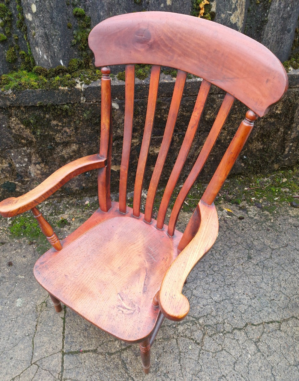 A Victorian wooden slat back Windsor armchair with turned legs, flat armrests, and a shaped saddle seat. View II