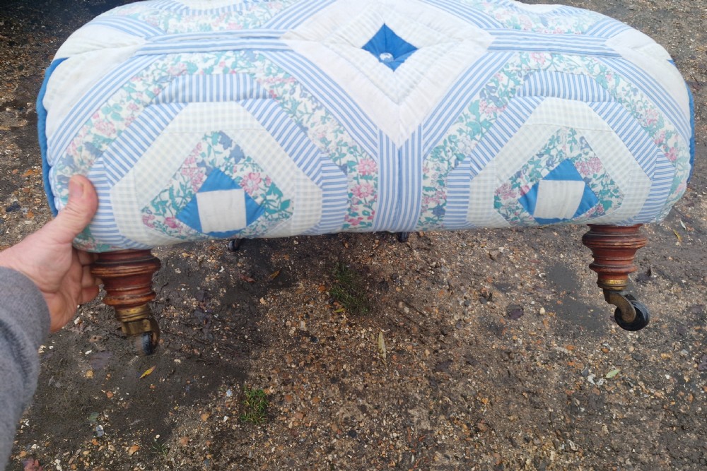A late Victorian upholstered day bed with an S-shaped contour, blue and white patterned fabric, turned timber legs, and small wheel castors. View III
