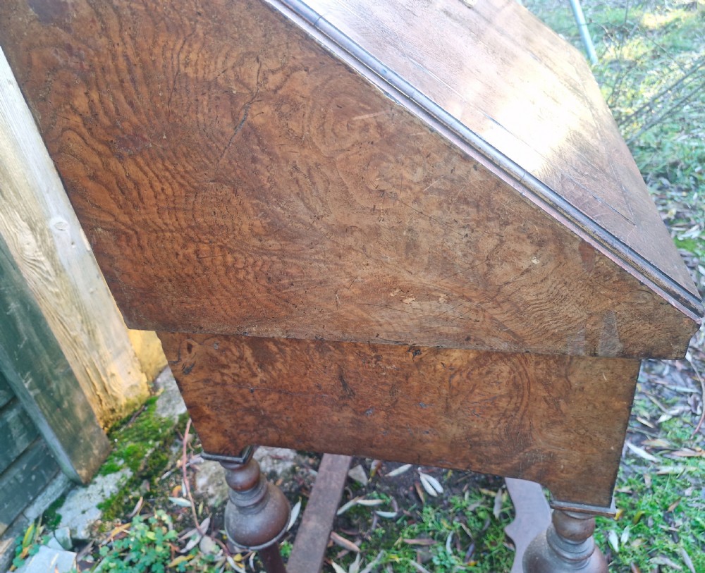 A Queen Anne style burr walnut and burr elm slant-front writing bureau raised on turned legs with a stretcher base. View IV