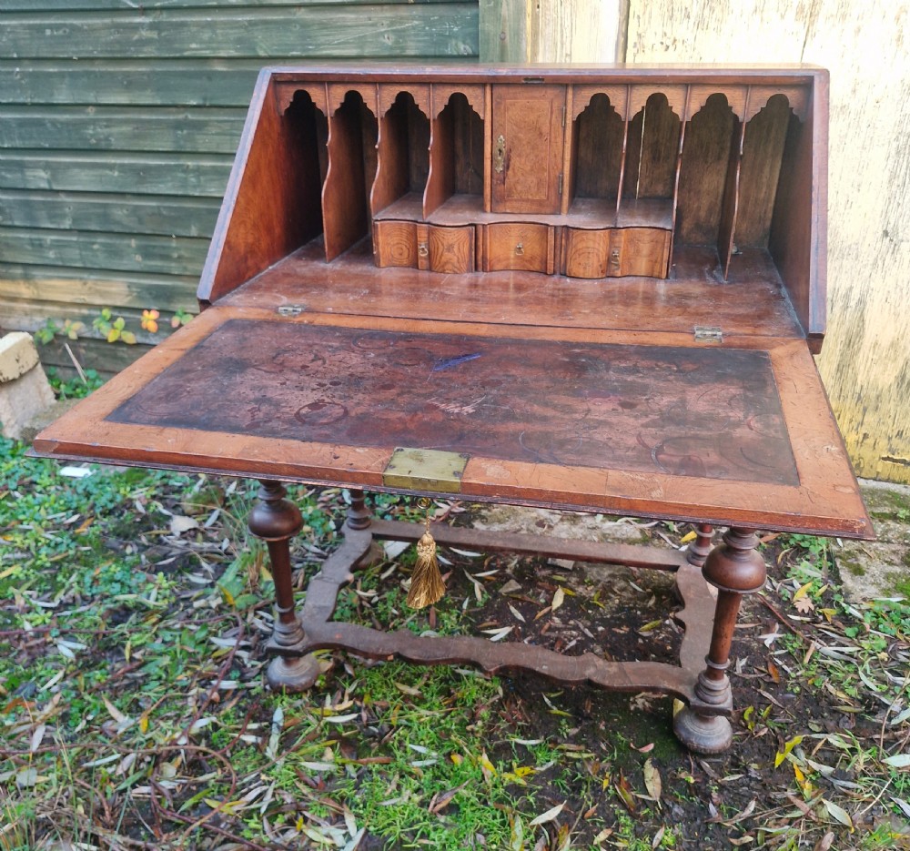 A Queen Anne style burr walnut and burr elm slant-front writing bureau raised on turned legs with a stretcher base. View VII