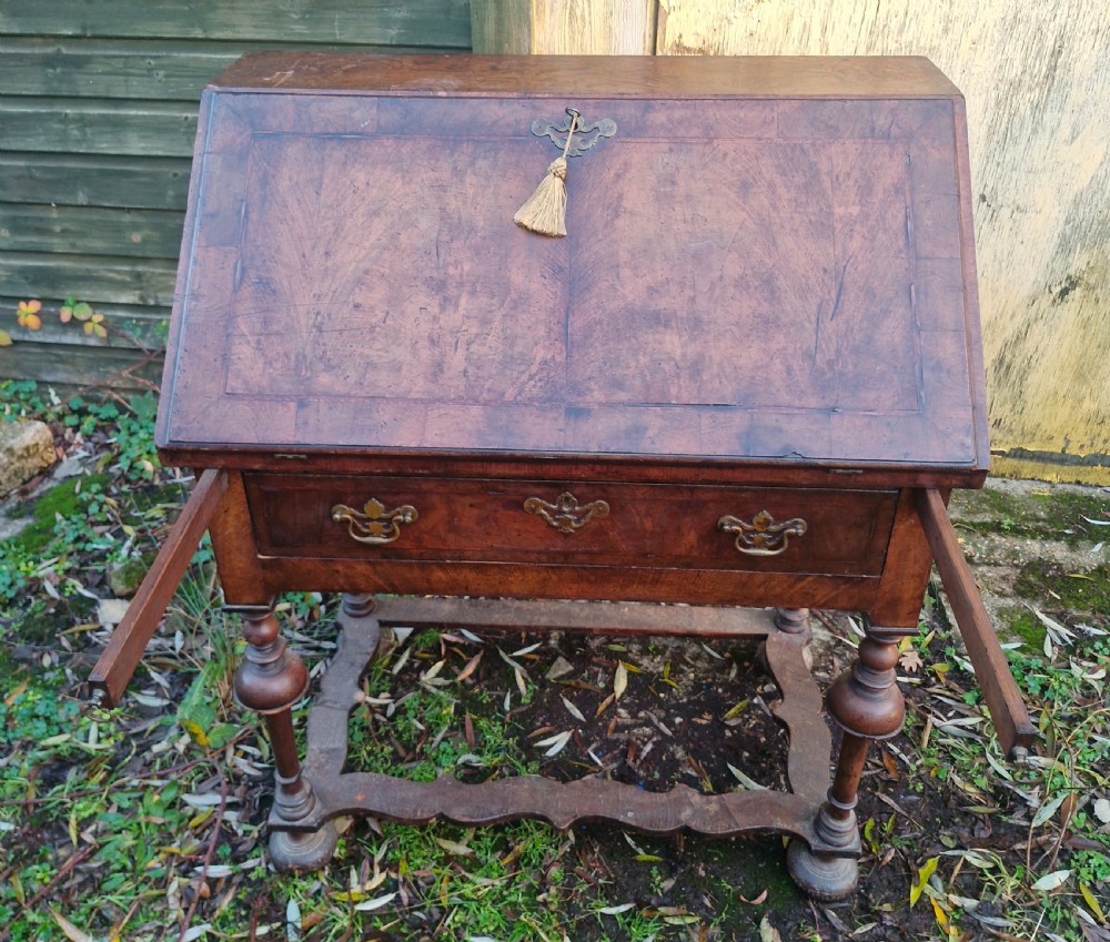 A Queen Anne style burr walnut and burr elm slant-front writing bureau raised on turned legs with a stretcher base. View IX