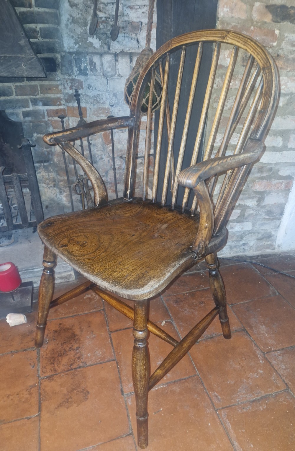 A 19th-century dark wooden Windsor armchair featuring a curved stick back, sculpted seat, curved armrests, and turned legs. View II