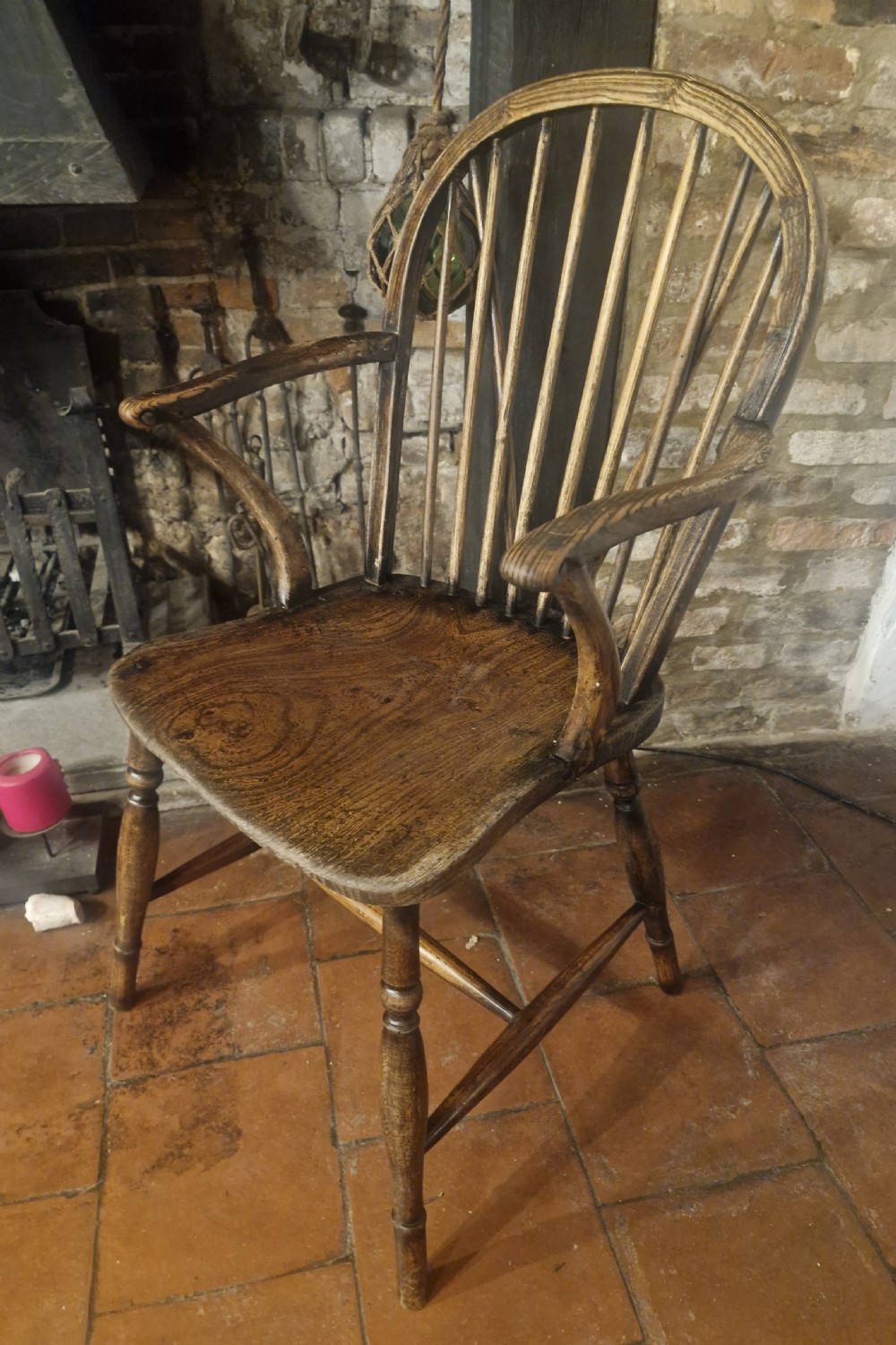 A 19th-century dark wooden Windsor armchair featuring a curved stick back, sculpted seat, curved armrests, and turned legs. View III