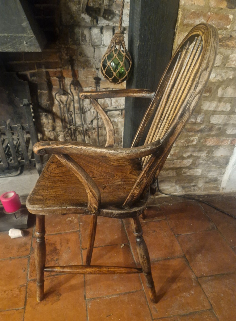 A 19th-century dark wooden Windsor armchair featuring a curved stick back, sculpted seat, curved armrests, and turned legs. View VI