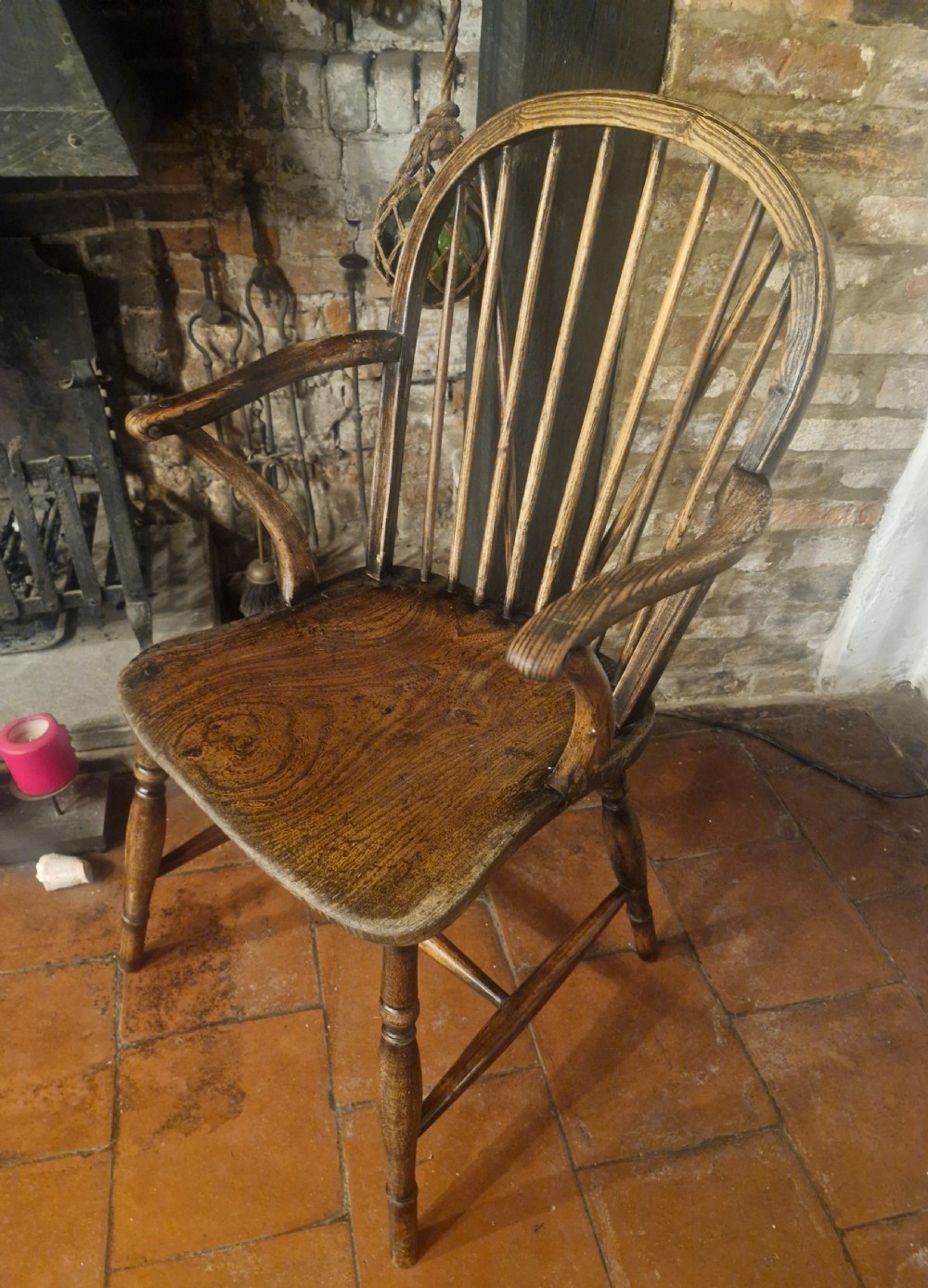 A 19th-century dark wooden Windsor armchair featuring a curved stick back, sculpted seat, curved armrests, and turned legs. View VII