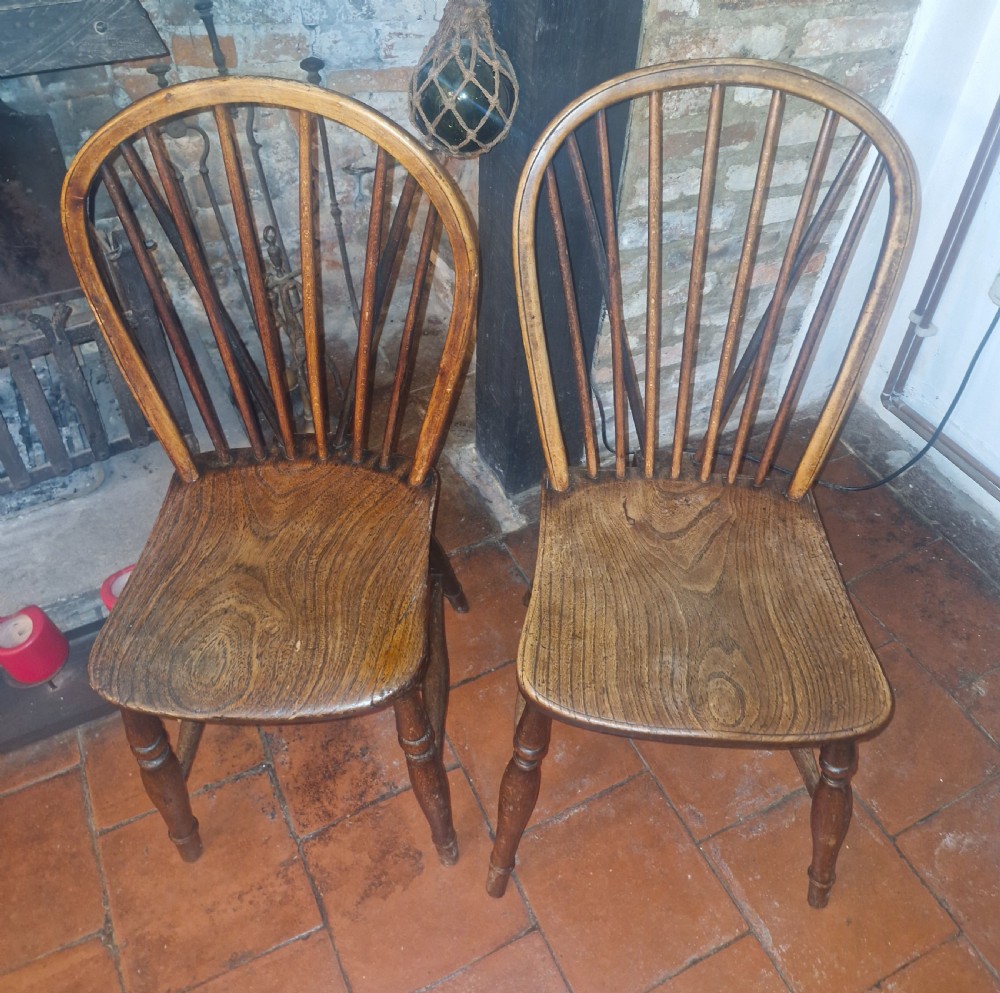 A pair of Victorian stick back Windsor kitchen chairs crafted from timber with contoured seats and turned front legs. View IV