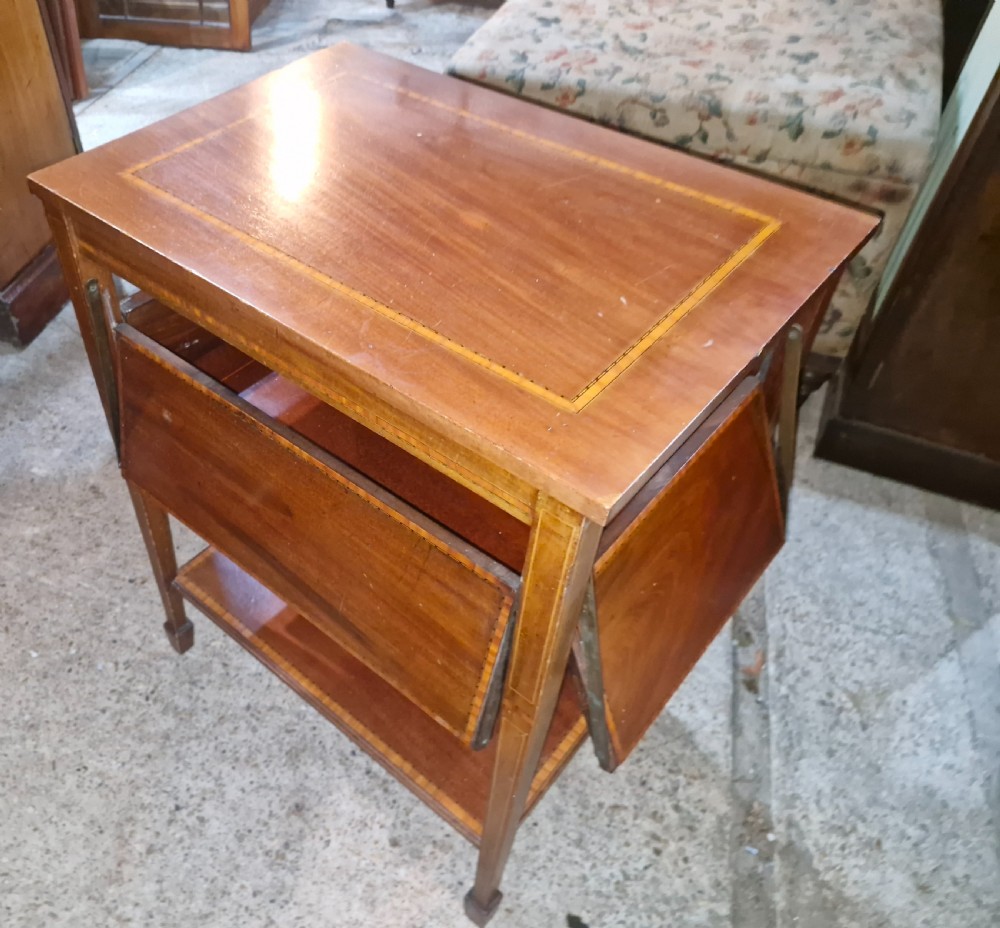 An Edwardian mahogany tea table featuring satinwood string inlay, four drop-down flap leaves, a lower tier shelf, and tapered legs. View IV