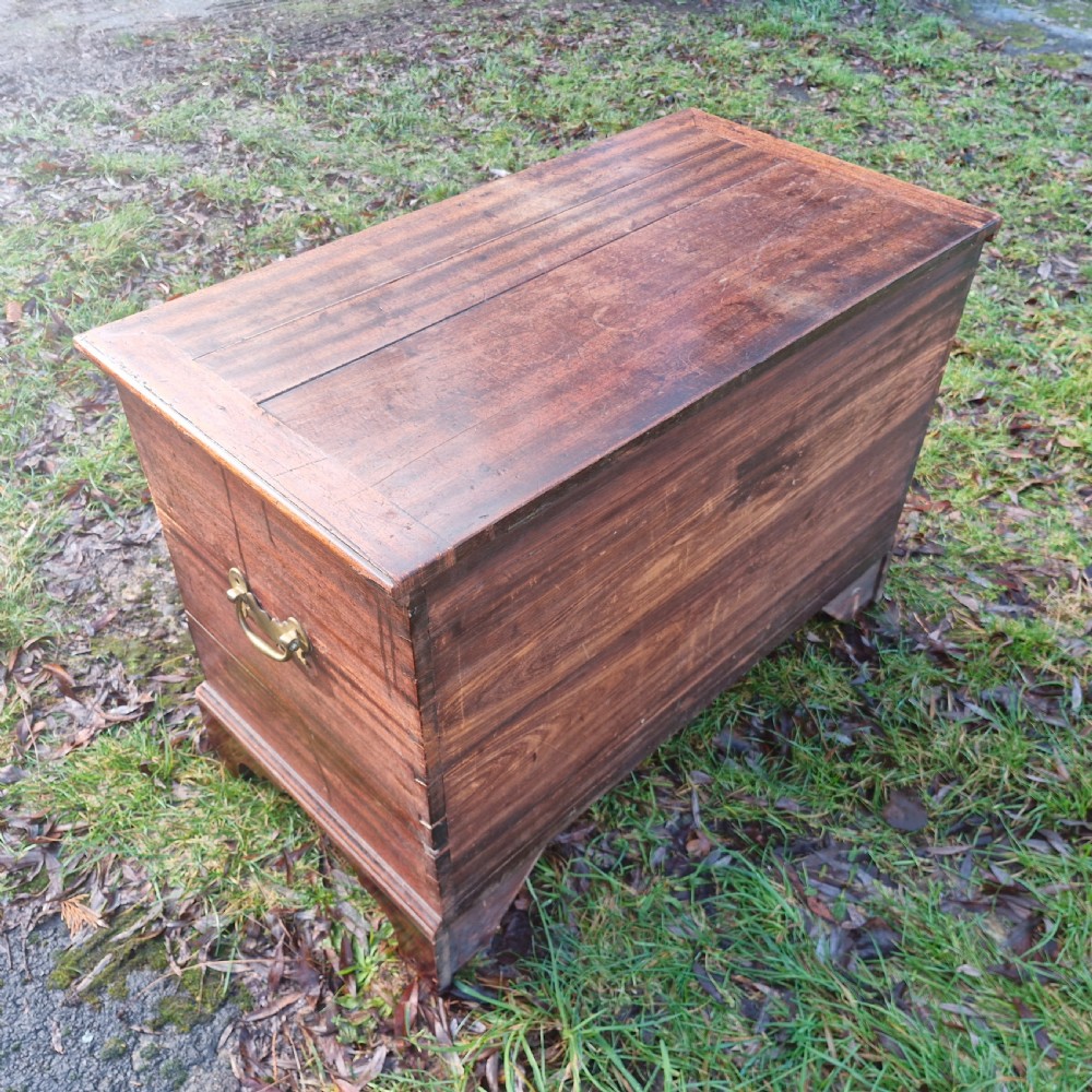 An early 19th-century mahogany mule chest featuring a hinged top lid, brass keyhole escutcheon, two lower drawers with brass drop handles, resting on bracket feet. View II