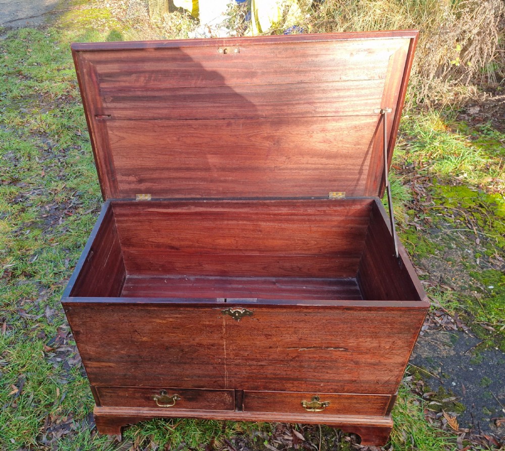 An early 19th-century mahogany mule chest featuring a hinged top lid, brass keyhole escutcheon, two lower drawers with brass drop handles, resting on bracket feet. View III