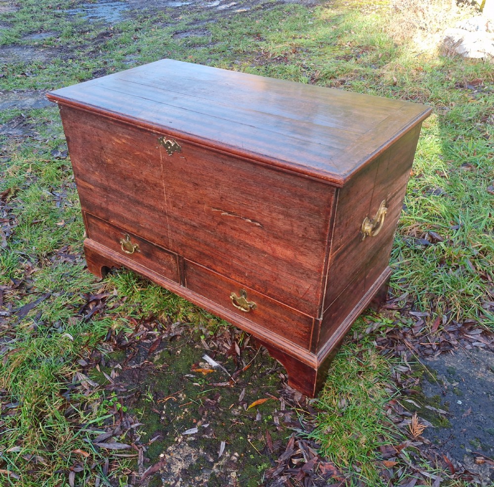 An early 19th-century mahogany mule chest featuring a hinged top lid, brass keyhole escutcheon, two lower drawers with brass drop handles, resting on bracket feet. View V