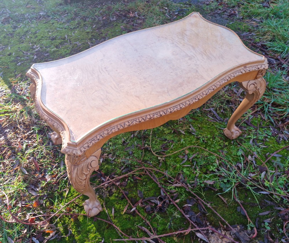 A low rectangular bleached walnut coffee table featuring a glass top insert, carved apron detailing, and cabriole legs. View II