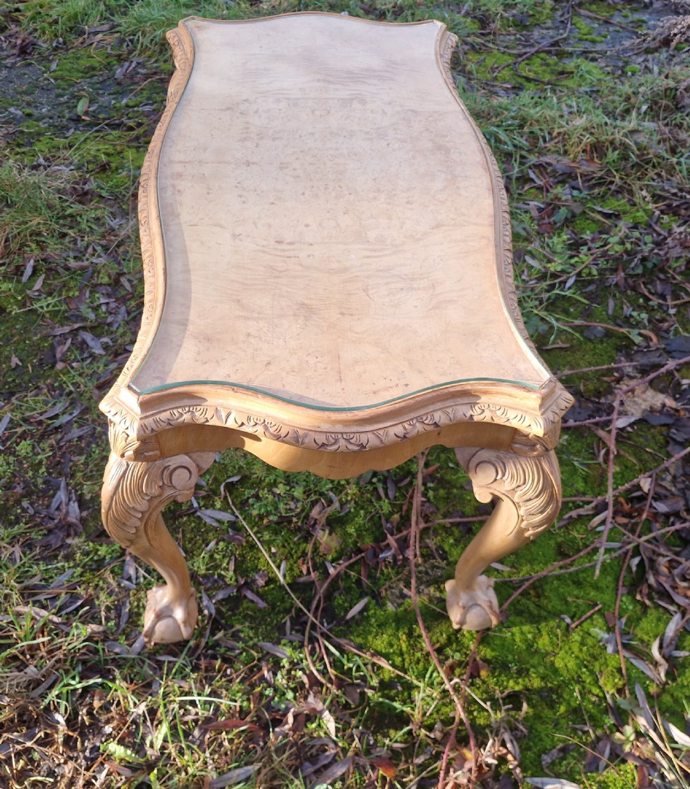 A low rectangular bleached walnut coffee table featuring a glass top insert, carved apron detailing, and cabriole legs. View III