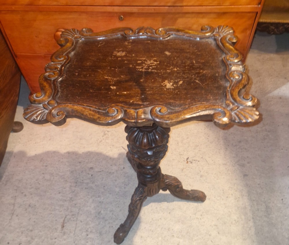 A late Victorian dark oak occasional table featuring a shaped moulded top, a heavily turned gadrooned column, and carved tripod cabriole legs. View II