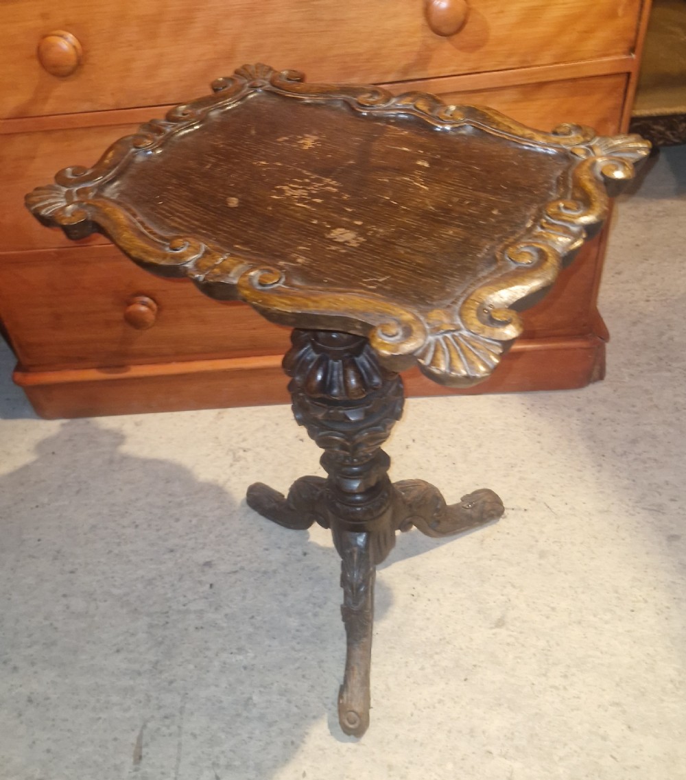 A late Victorian dark oak occasional table featuring a shaped moulded top, a heavily turned gadrooned column, and carved tripod cabriole legs. View III