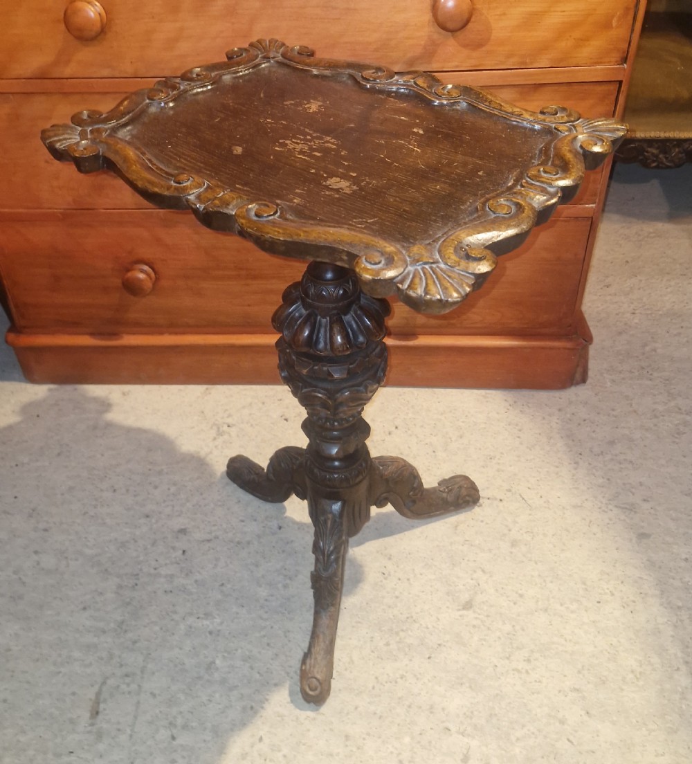 A late Victorian dark oak occasional table featuring a shaped moulded top, a heavily turned gadrooned column, and carved tripod cabriole legs. View IV