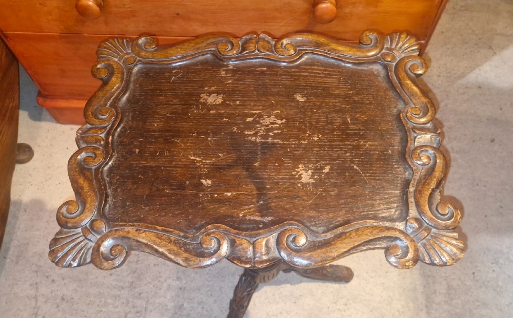 A late Victorian dark oak occasional table featuring a shaped moulded top, a heavily turned gadrooned column, and carved tripod cabriole legs. View V