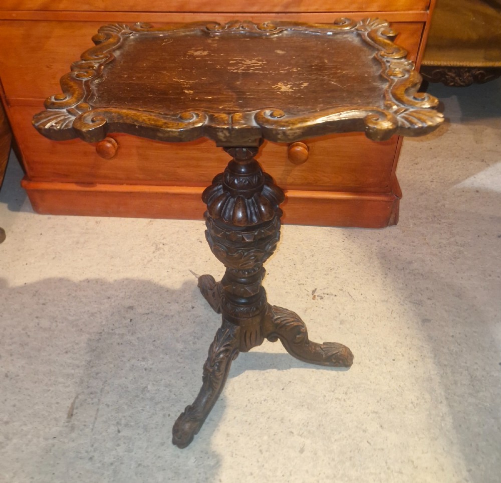 A late Victorian dark oak occasional table featuring a shaped moulded top, a heavily turned gadrooned column, and carved tripod cabriole legs. View VI