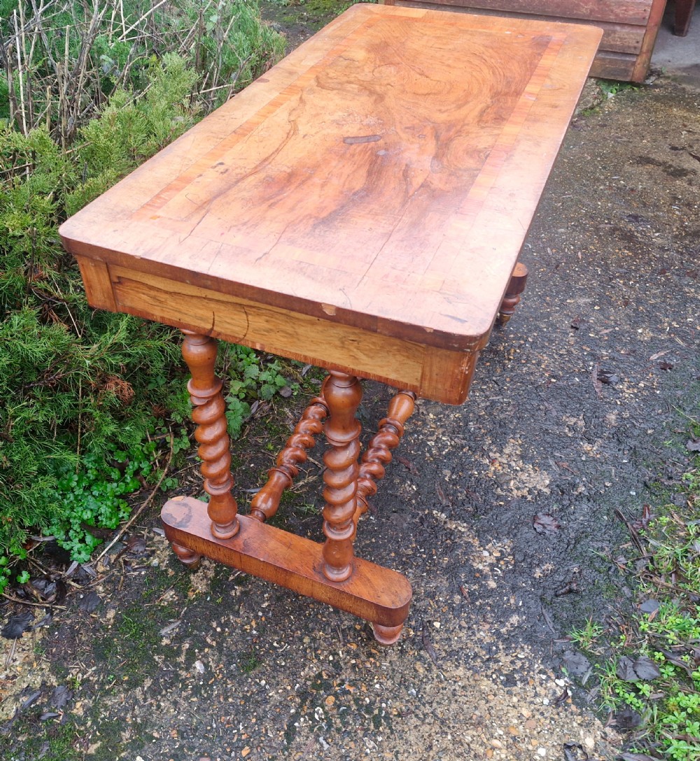 A Victorian walnut side table featuring a rectangular inlaid top, two frieze drawers, and turned barley twist legs connected by stretchers on brass castors. View III