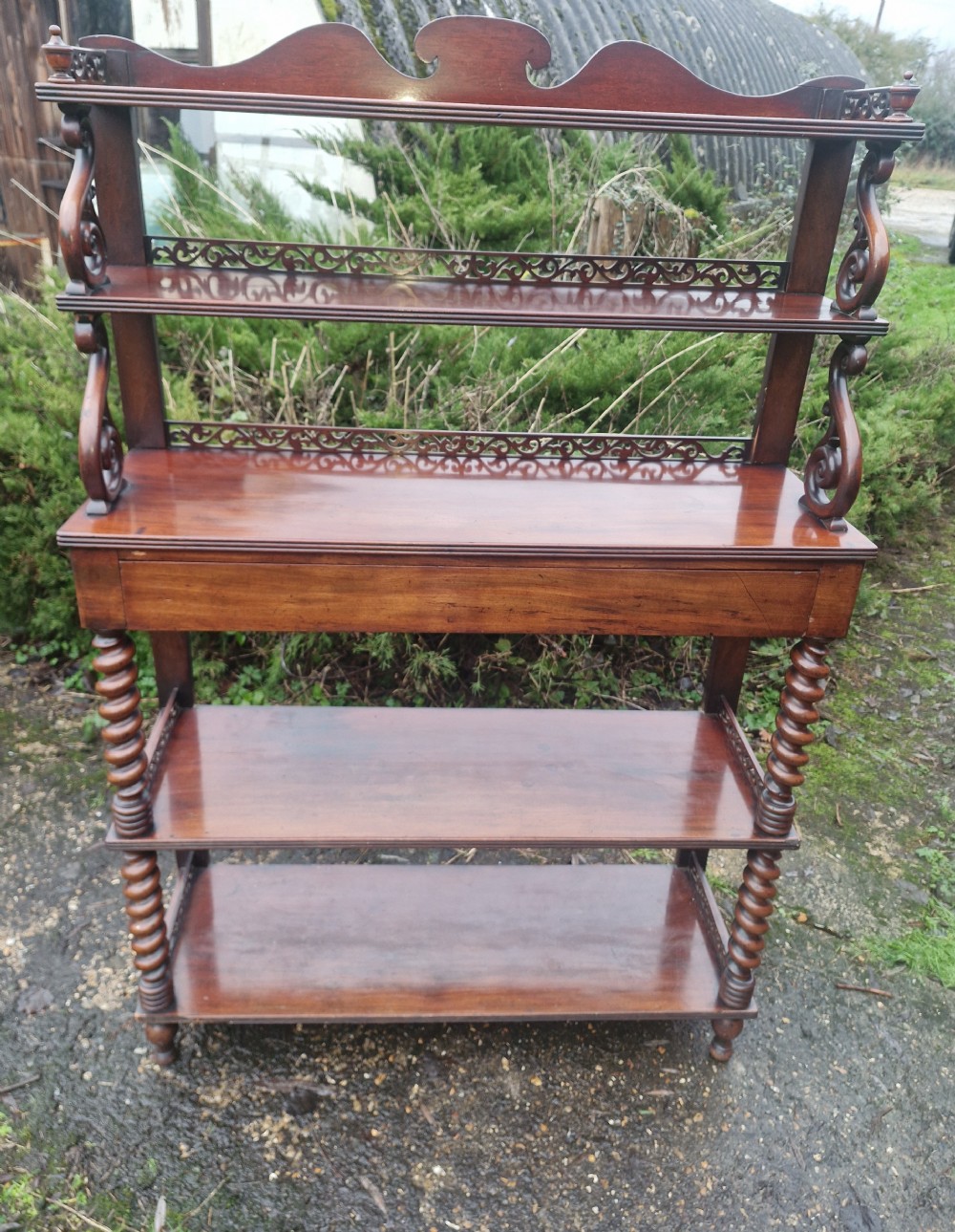 A mid-19th-century mahogany etagere featuring multiple open tiers, decorative fretwork galleries, carved scroll supports, lower barley-twist columns, and a central single drawer. View III