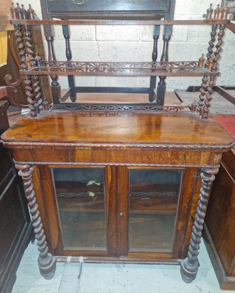 A mid-19th-century rosewood side cabinet with double glazed doors, barley twist column supports, and a two-tier open shelf superstructure with carved fretwork galleries.