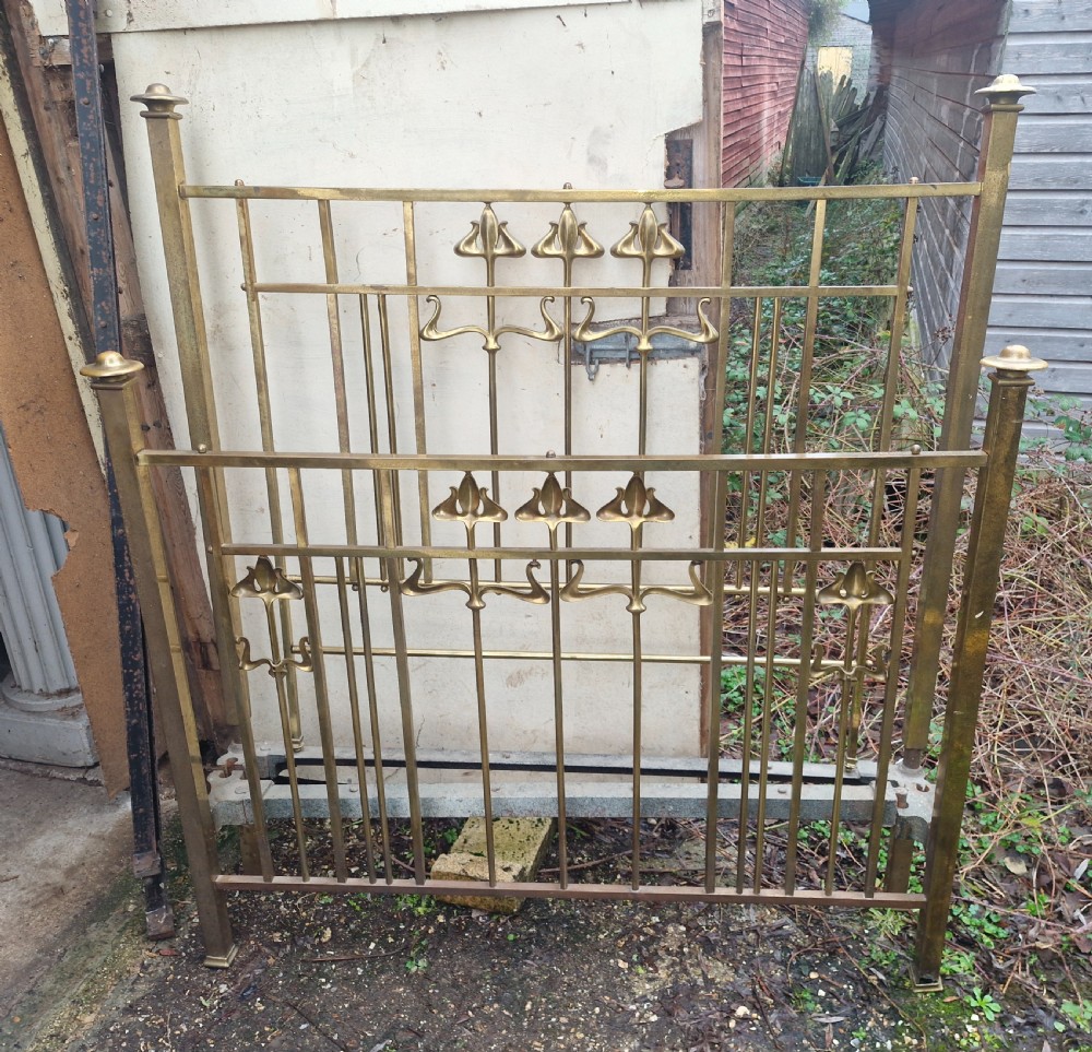 An Art Nouveau brass double bed frame with headboard, footboard, and original side irons featuring stylized floral motifs. View II