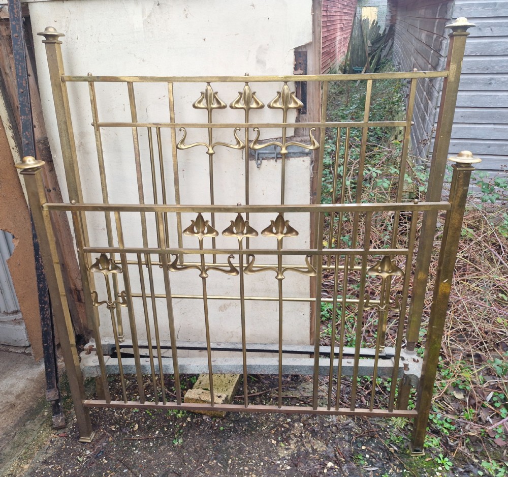 An Art Nouveau brass double bed frame with headboard, footboard, and original side irons featuring stylized floral motifs. View III