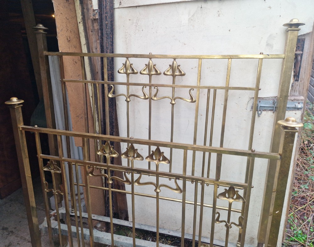 An Art Nouveau brass double bed frame with headboard, footboard, and original side irons featuring stylized floral motifs. View IV