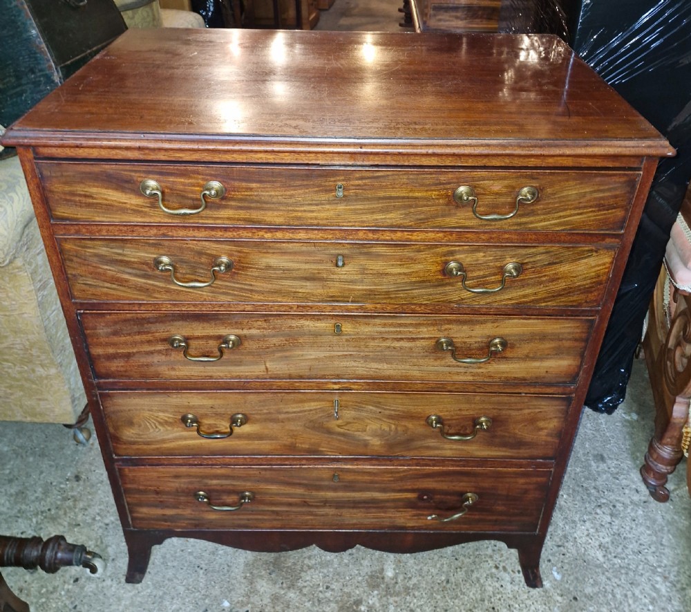 A Regency mahogany secretaire chest featuring five drawer fronts with brass swan-neck handles, keyhole escutcheons, and a shaped apron base.