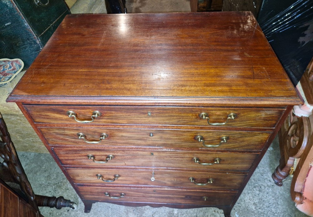 A Regency mahogany secretaire chest featuring five drawer fronts with brass swan-neck handles, keyhole escutcheons, and a shaped apron base. View VI