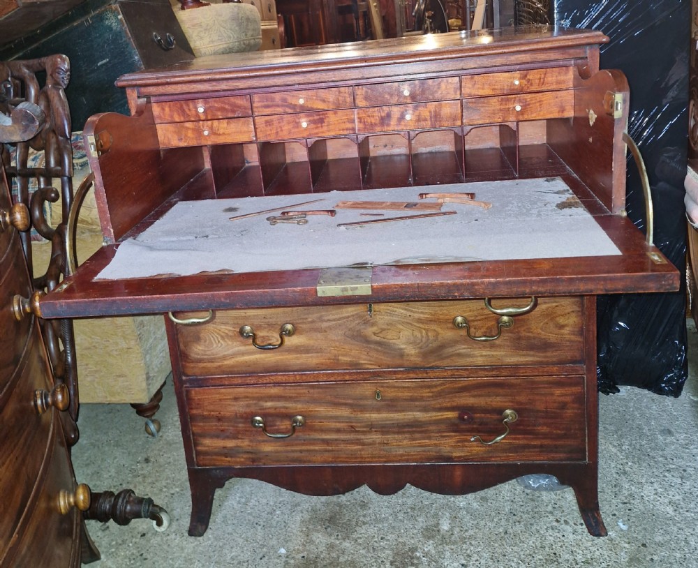 A Regency mahogany secretaire chest featuring five drawer fronts with brass swan-neck handles, keyhole escutcheons, and a shaped apron base. View X