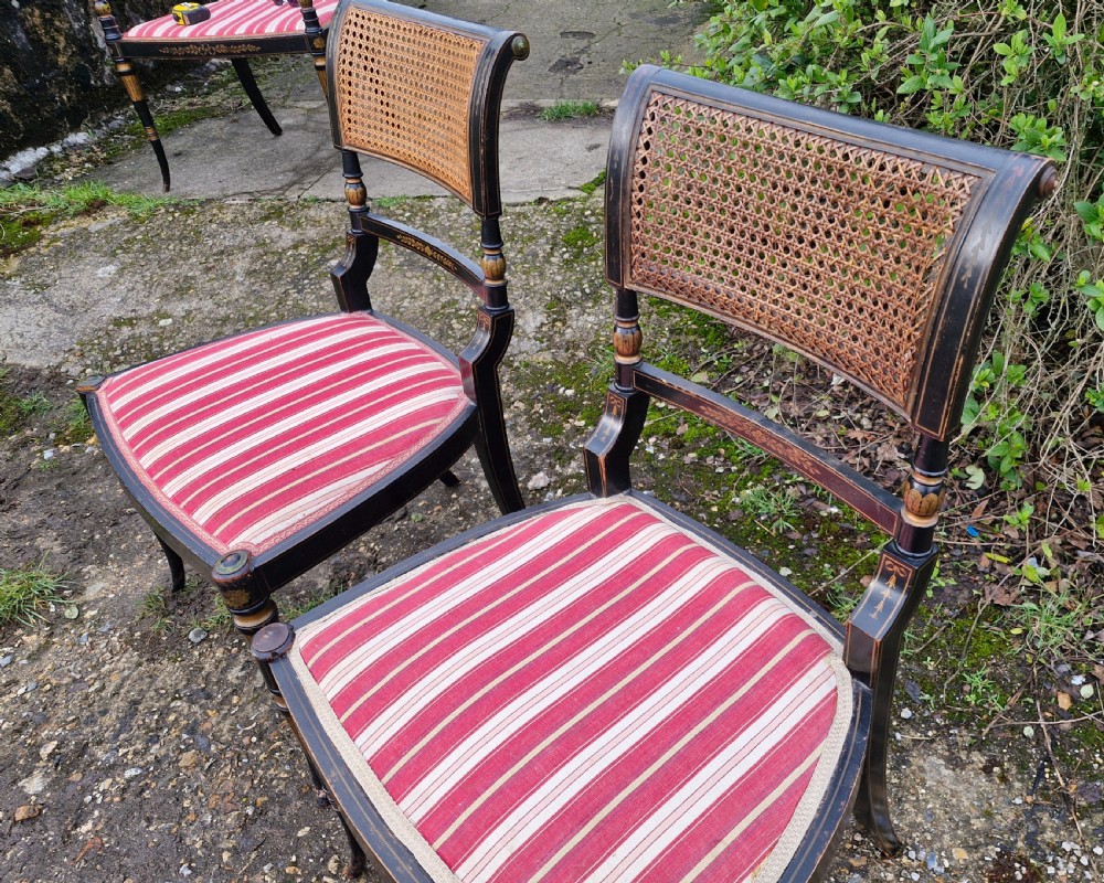 Pair of black painted antique side chairs featuring woven cane backrests, gold floral hand-painted details, and red and cream striped upholstered seats. View VIII
