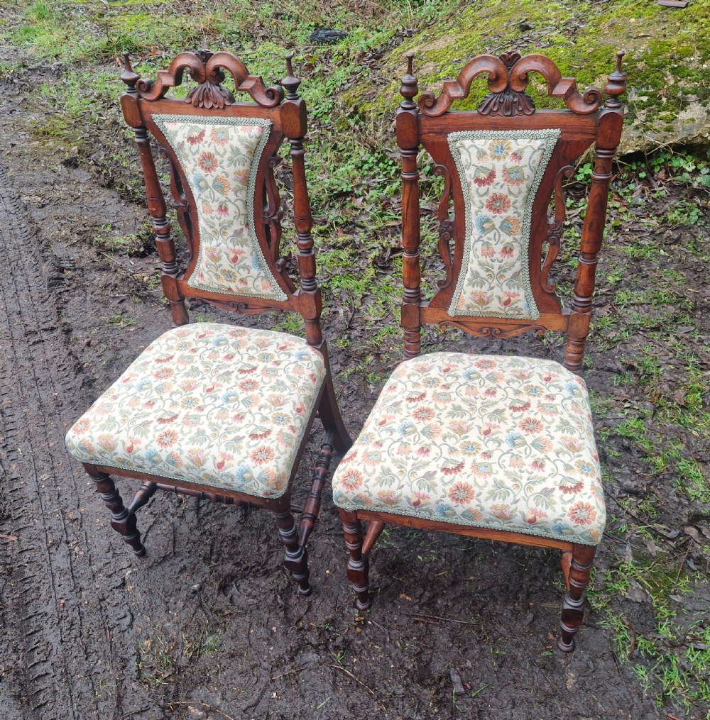 A pair of mid-19th century carved rosewood side chairs with floral tapestry upholstered seats and back pads.