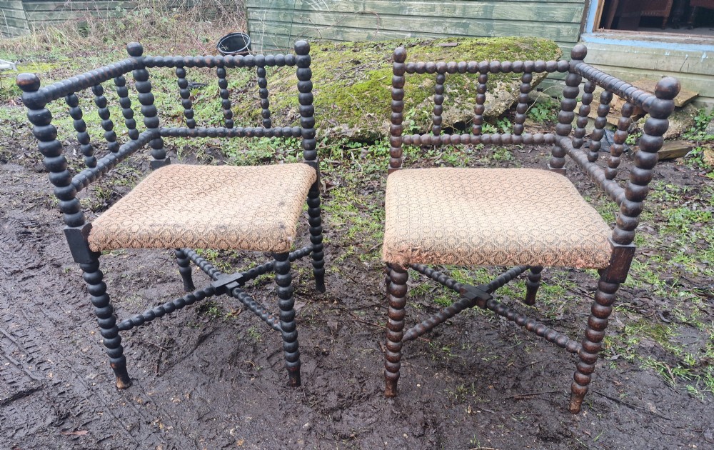 A pair of dark wood bobbin-turned corner chairs featuring patterned fabric seats and crossed lower stretchers. View III