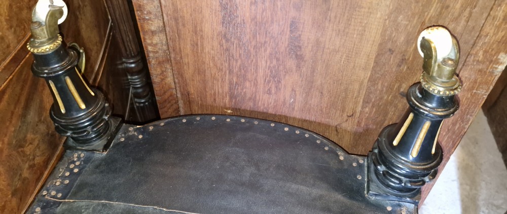A pair of low Victorian ebonised nursing chairs with spindle backrests, turned front legs on ceramic castors, and worn yellow upholstery. View VI
