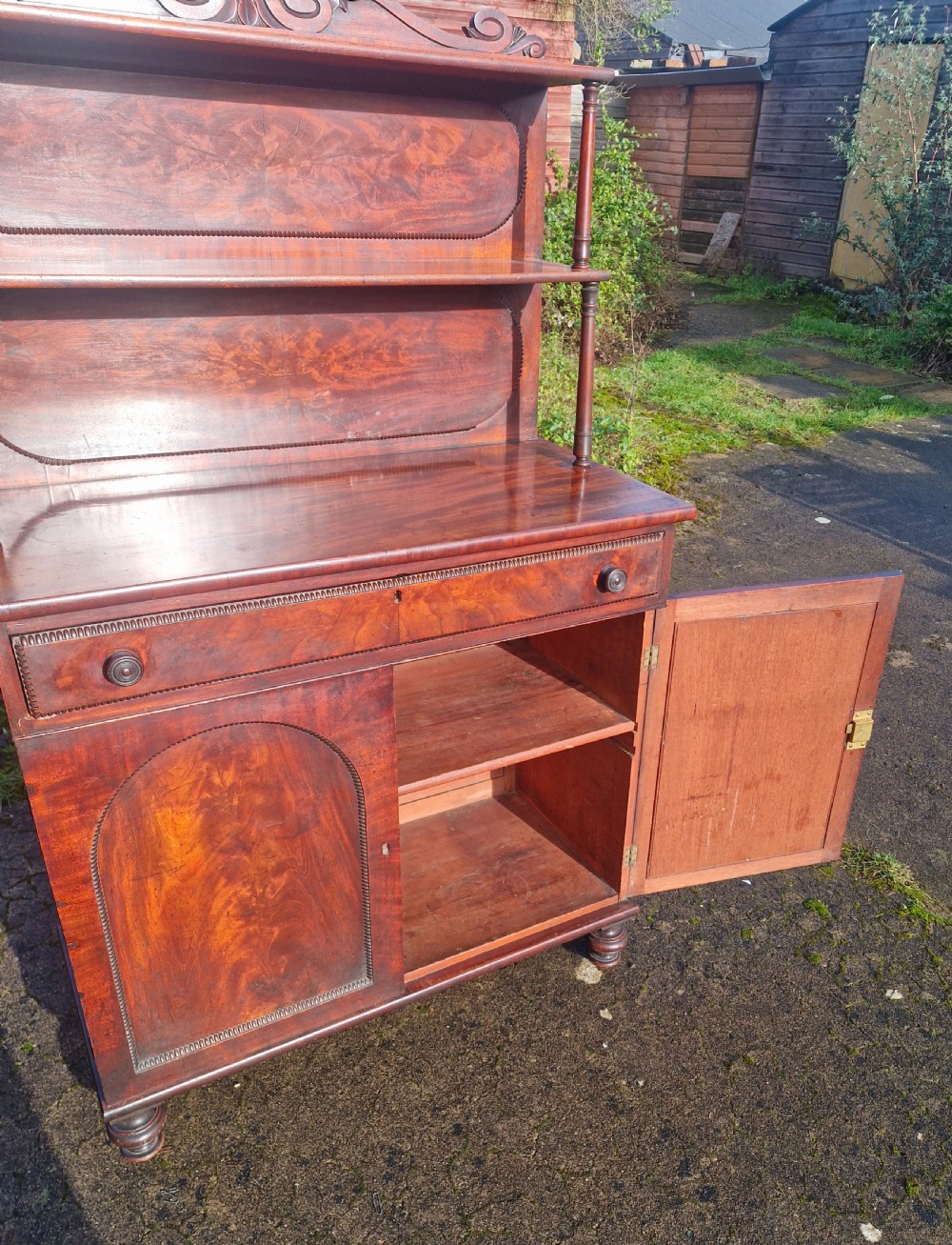 A Regency mahogany side cabinet featuring a two-shelf upper superstructure with turned columns, a top drawer, and a two-door lower cupboard with arch-moulded panels. View III