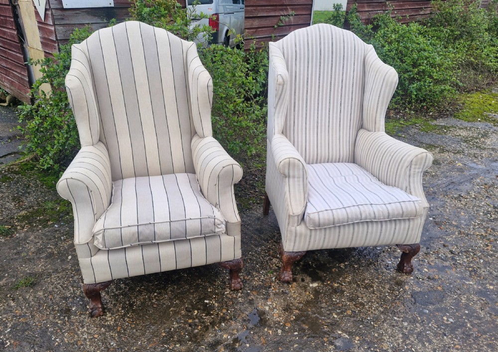 A pair of high-backed upholstered wingback armchairs featuring striped beige fabric and carved wooden cabriole legs with ball and claw feet. View II
