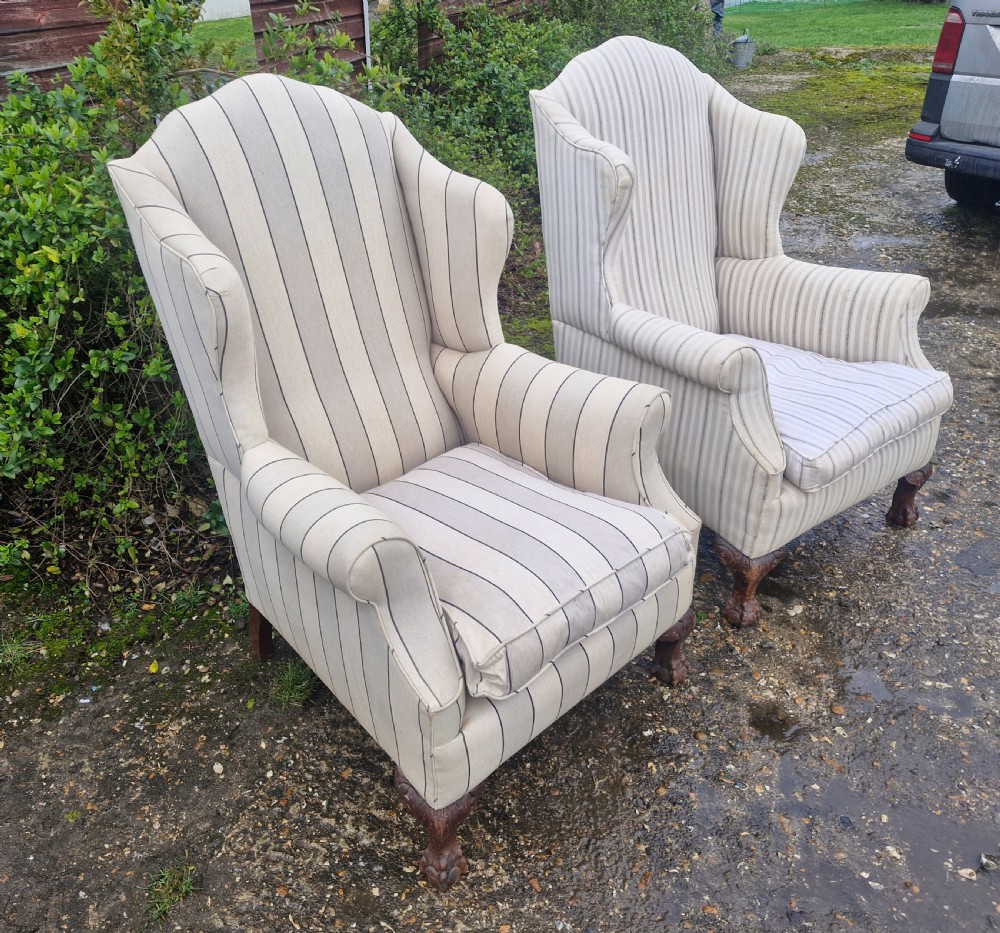 A pair of high-backed upholstered wingback armchairs featuring striped beige fabric and carved wooden cabriole legs with ball and claw feet. View III