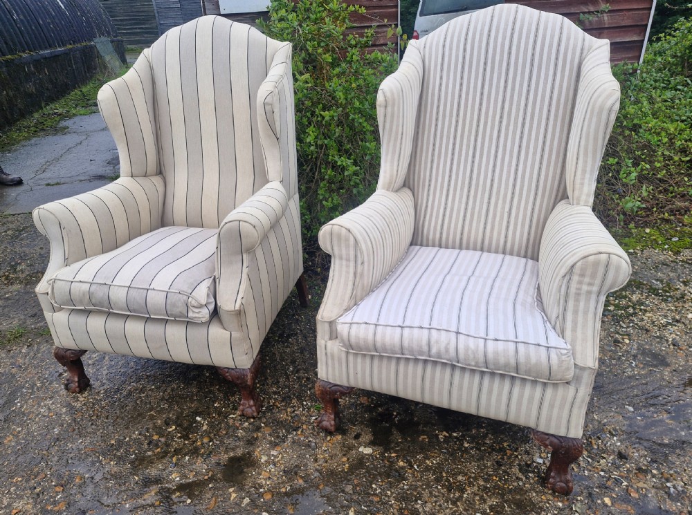 A pair of high-backed upholstered wingback armchairs featuring striped beige fabric and carved wooden cabriole legs with ball and claw feet. View VI