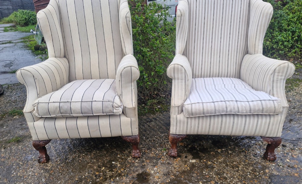 A pair of high-backed upholstered wingback armchairs featuring striped beige fabric and carved wooden cabriole legs with ball and claw feet. View VIII