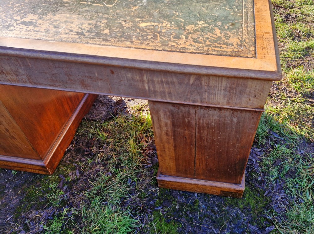 A Victorian walnut breakfront pedestal desk with a distressed green leather inset top and brass drop handles. View IV