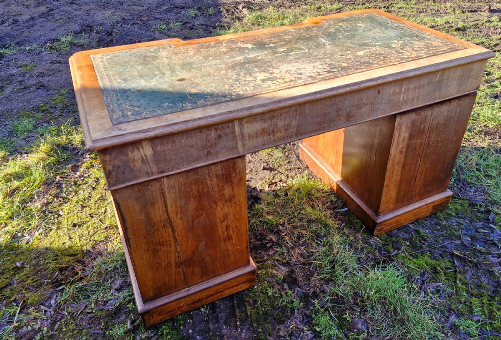 A Victorian walnut breakfront pedestal desk with a distressed green leather inset top and brass drop handles. View IX