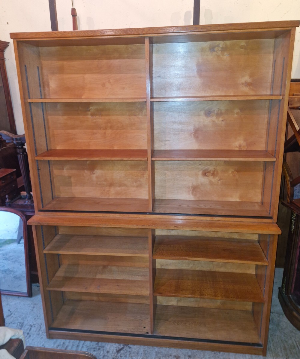 A tall open-front warm brown oak bookcase featuring two vertical columns with multiple adjustable wooden shelves. View VIII