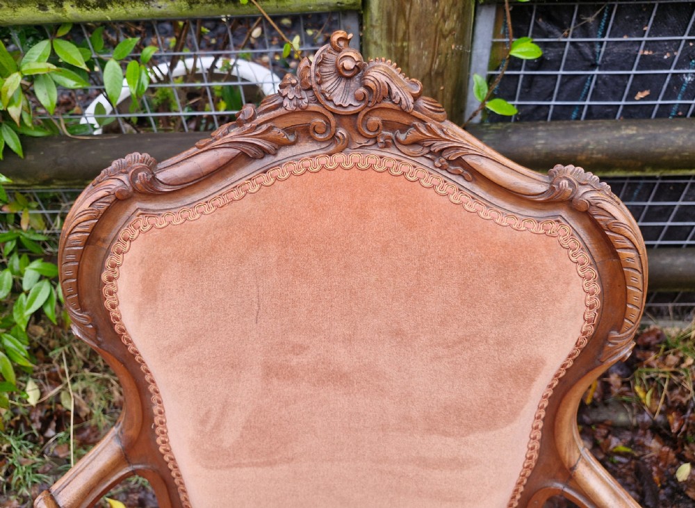 A pair of French Louis XV style carved walnut fauteuil armchairs with open padded armrests and peach velvet upholstery. View III