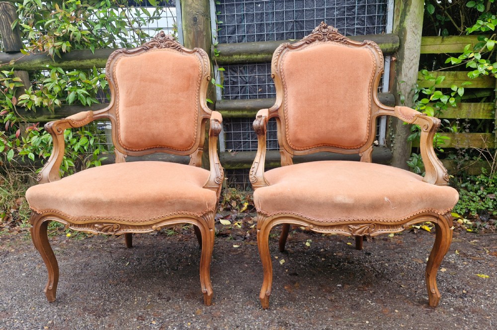 A pair of French Louis XV style carved walnut fauteuil armchairs with open padded armrests and peach velvet upholstery. View V