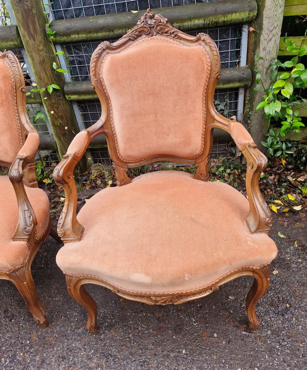 A pair of French Louis XV style carved walnut fauteuil armchairs with open padded armrests and peach velvet upholstery. View VI