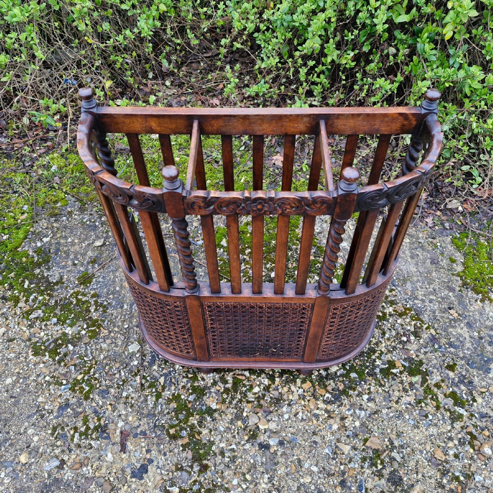 A carved dark oak stick and umbrella stand featuring barley twist supports, vertical wooden slats, and lower woven cane panels. View III