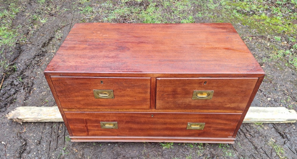 A low mahogany campaign chest of drawers with recessed brass handles and keyholes. View IV