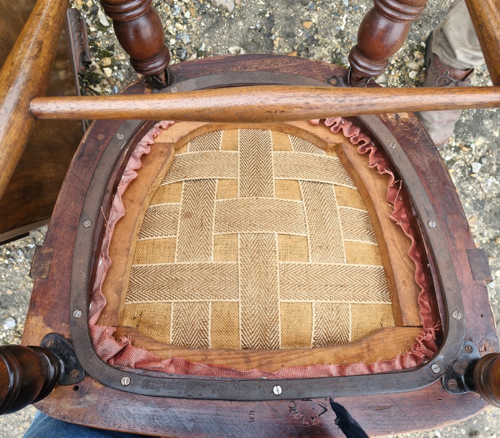 An early 20th-century mahogany military desk armchair featuring a spindle back, turned front legs, and a padded seat. View III