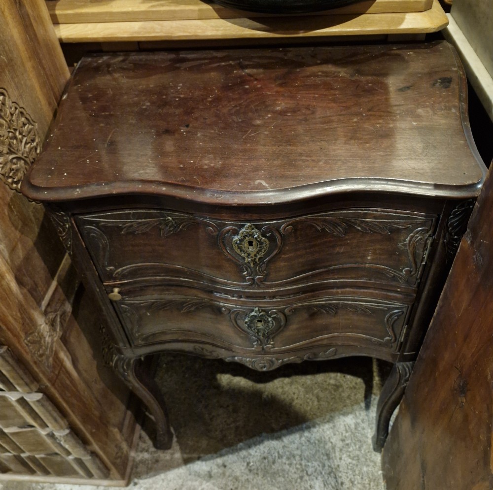 Early 19th-century dark wood bedside cabinet featuring carved floral panels, brass escutcheons, and slender cabriole legs. View VI
